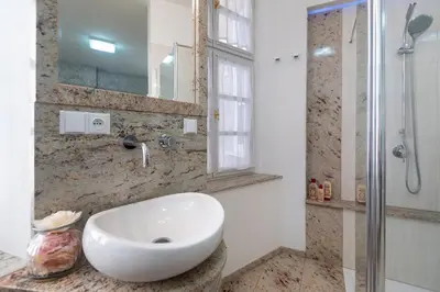 a bathroom with a white sink and a shower at Quiet apartment in the heart of Old Town centre in Prague