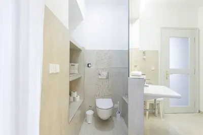 a white bathroom with a toilet and a sink at Stylish, Light-Filled Home in the Historic Center in Prague