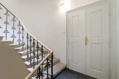 a stairway with a white door and a white wall at Stylish, Light-Filled Home in the Historic Center in Prague