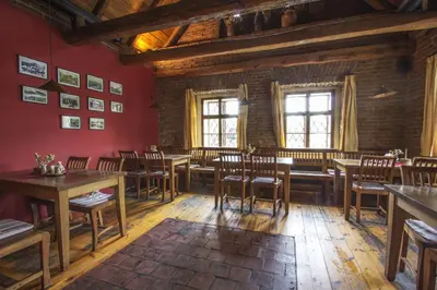 a restaurant with wooden tables and chairs in a room at Penzion Ve stoleti in Loděnice