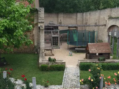a garden with a playground in the back of a building at Penzion Ve stoleti in Loděnice