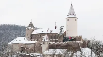 a large castle with a tall building and a tower at Penzion a Restaurace Nad Hradem in Křivoklát