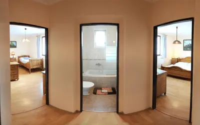a bathroom with a tub and a toilet and a bedroom at Penzion a Restaurace Nad Hradem in Křivoklát
