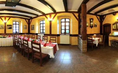 a restaurant with tables and chairs in a room at Penzion a Restaurace Nad Hradem in Křivoklát