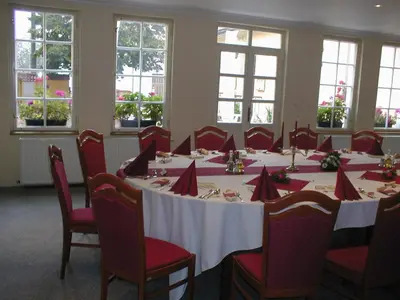 a conference room with a long table with red chairs at Penzion a Restaurace Nad Hradem in Křivoklát