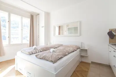 a room with white walls and a white couch at Cozy studio with parking near city center in Prague