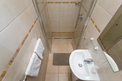 a small bathroom with a sink and a shower at Cozy studio with parking near city center in Prague