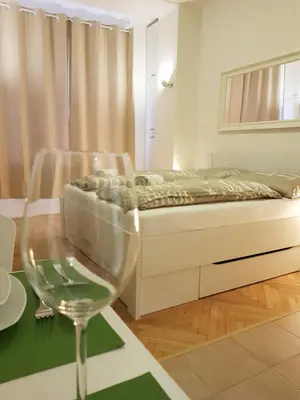 a bedroom with a bed and a table with a wine glass at Cozy studio with parking near city center in Prague