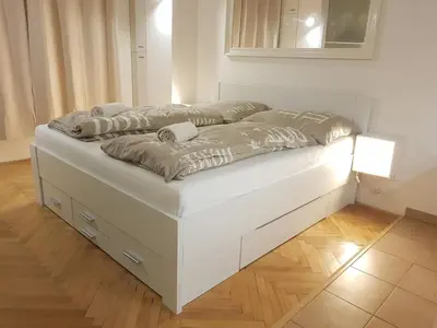 a white bed with two pillows on top of it at Cozy studio with parking near city center in Prague