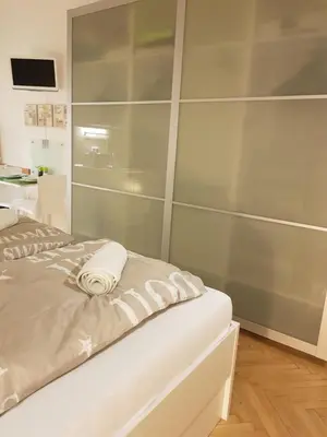 a bedroom with a bed with a wall of glass at Cozy studio with parking near city center in Prague