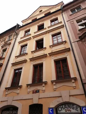 a tall yellow building with red windows at Historic Centre Apartments VIII in Prague