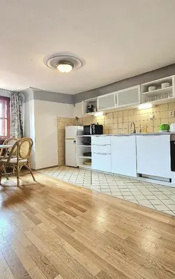 a kitchen with white cabinets and a table and chairs at Historic Centre Apartments VIII in Prague