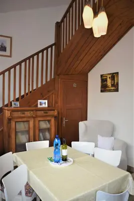 a dining room with a table and white chairs at Apartmány Pod vodárenskou věží in Poděbrady