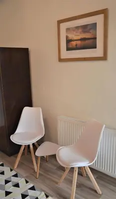 two white chairs in a room with a picture on the wall at Apartmány Pod vodárenskou věží in Poděbrady