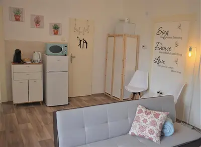 a living room with a couch and a refrigerator at Apartmány Pod vodárenskou věží in Poděbrady