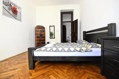 a bedroom with a black bed and a wooden floor at Spacious cozy apartments in centre in Prague