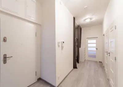 an empty hallway with white walls and wooden floors at Central Prague Crown Apartments in Prague