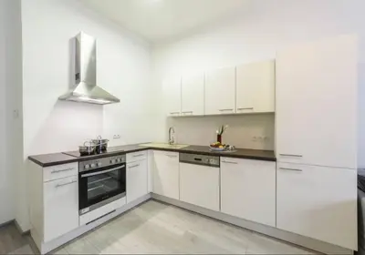 a white kitchen with white cabinets and a stove at Central Prague Crown Apartments in Prague