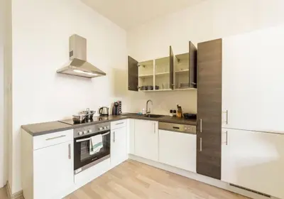 a kitchen with white cabinets and stainless steel appliances at Central Prague Crown Apartments in Prague
