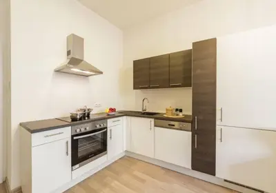a kitchen with white cabinets and a stainless steel refrigerator at Central Prague Crown Apartments in Prague