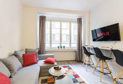 a living room with a couch and a tv at Central Prague Crown Apartments in Prague
