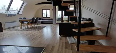 a living room with stairs and a table and chairs at Rooftop Deluxe apartment in Prague