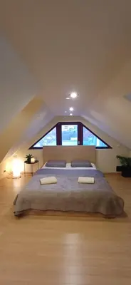 a bedroom with a large bed in front of a window at Rooftop Deluxe apartment in Prague
