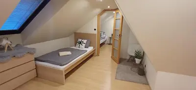 a small attic bedroom with a bed and a window at Rooftop Deluxe apartment in Prague