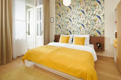 a bedroom with a large bed with a yellow blanket at City Nest Apartments by Adrez in Prague