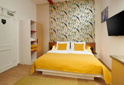 a bedroom with a bed with a yellow blanket at City Nest Apartments by Adrez in Prague