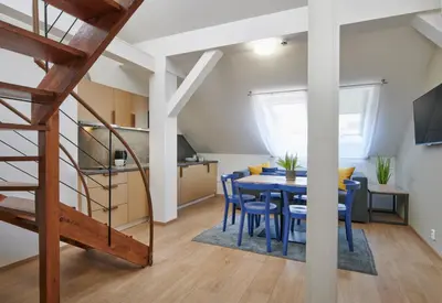 a kitchen and dining room with a table and blue chairs at City Nest Apartments by Adrez in Prague