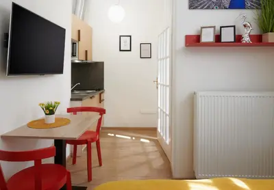 a living room with a table and a tv on a wall at City Nest Apartments by Adrez in Prague