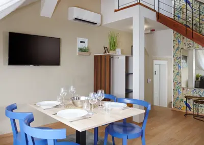 a dining room with a table and blue chairs at City Nest Apartments by Adrez in Prague