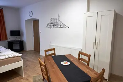a dining room with a wooden table and chairs at Krejčovství in Mělník