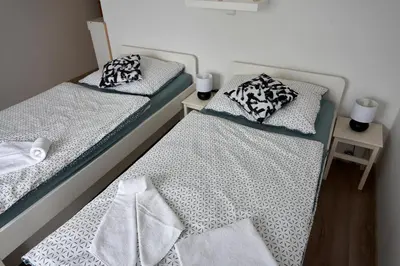 two beds in a small room with towels at Krejčovství in Mělník