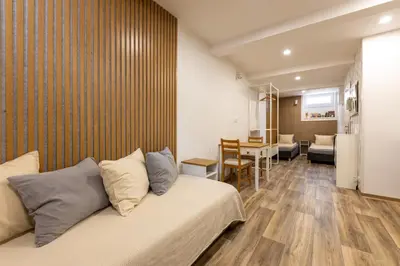 a room with two beds and a table at VOUSATÁ Dáma in Prague