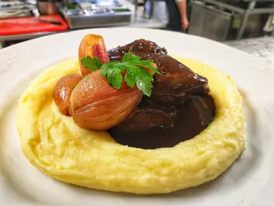 a plate of food with meat and chocolate sauce at Park Hotel Popovicky in Popovičky