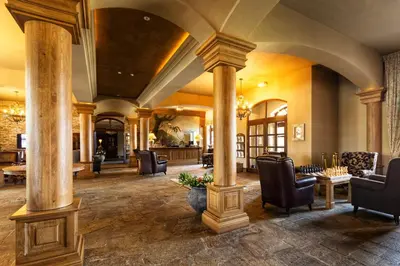 a lobby with columns and chairs in a building at Park Hotel Popovicky in Popovičky