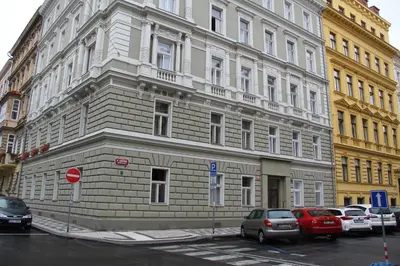 a large building with cars parked in front of it at Apartment Vltava Prague in Prague