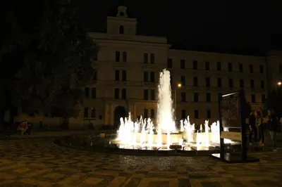 a fountain in front of a large building at night at Apartment Vltava Prague in Prague