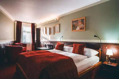 a bedroom with a large bed with a red blanket at Hotel Hastal Prague Old Town in Prague
