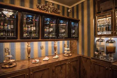 a bar with wooden cabinets and shelves with glasses at Hotel Hastal Prague Old Town in Prague