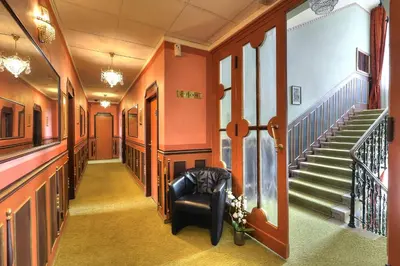 a hallway with stairs and a chair in a building at Hotel Hastal Prague Old Town in Prague