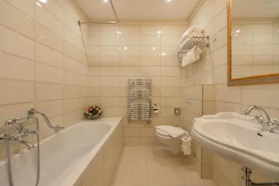 a bathroom with a tub and a toilet and a sink at Hotel Hastal Prague Old Town in Prague