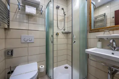 a bathroom with a shower and a toilet and a sink at Hotel Hastal Prague Old Town in Prague
