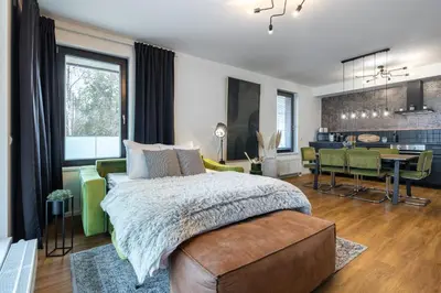 a bedroom with a large bed and a dining room at Apartment Invalidovna with FREE parking in Prague