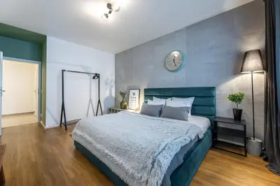 a bedroom with a large bed and a clock on the wall at Apartment Invalidovna with FREE parking in Prague