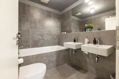 a bathroom with two sinks and a tub and a toilet at Apartment Invalidovna with FREE parking in Prague