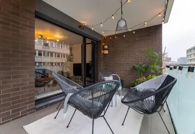 three chairs and a table on a balcony at Apartment Invalidovna with FREE parking in Prague