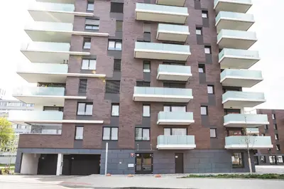 a tall red brick building with white balconies at Apartment Invalidovna with FREE parking in Prague